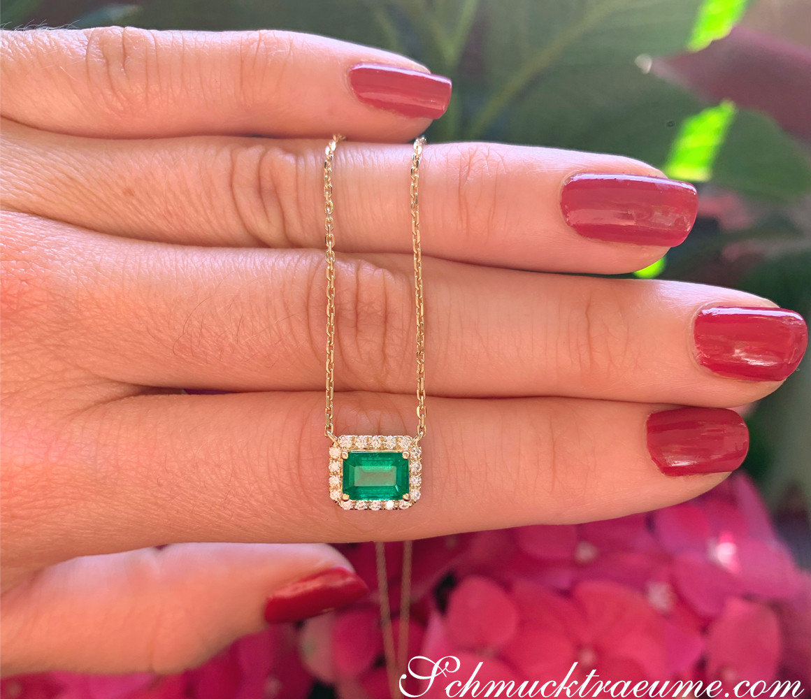 Smaragd-Halskette mit Brillanten in Gelbgold 585, detailreich, grünes Grün, zarte Kette, roter Nagellack, Hintergrund mit