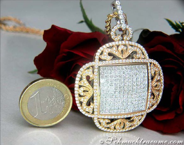 Goldener Diamantanhänger mit Rosetten-Verzierung, neben einem Euro-Schein und einer Rose.