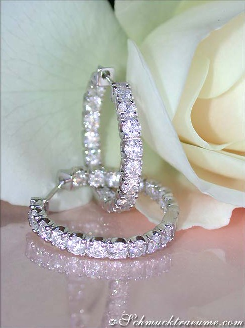 Detailansicht von Diamantcreolen in Weißgold, umgeben von Rosenblättern