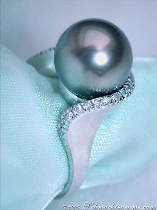 Tahitiperlen-Ring mit Brillanten in Weißgold auf zarter Stoffoberfläche