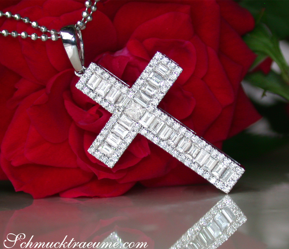 Diamantkreuzanhänger mit Baguette-Diamanten vor Rosenblüte