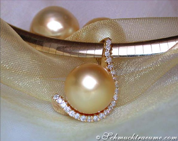 Goldener Südseeperlenanhänger mit Brillantenkragen, Detailaufnahme auf Satin.