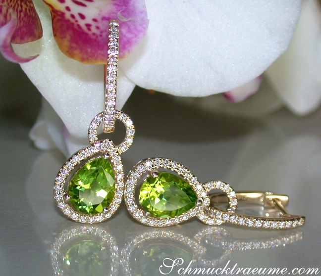 Peridot-Tropfen-Ohrringe mit Diamanten, Gelbgold 585, Orchidee im Hintergrund. Peridot-Tropfen-Ohrringe mit Diamanten, Gelbgold 585, Orchidee im Hintergrund.