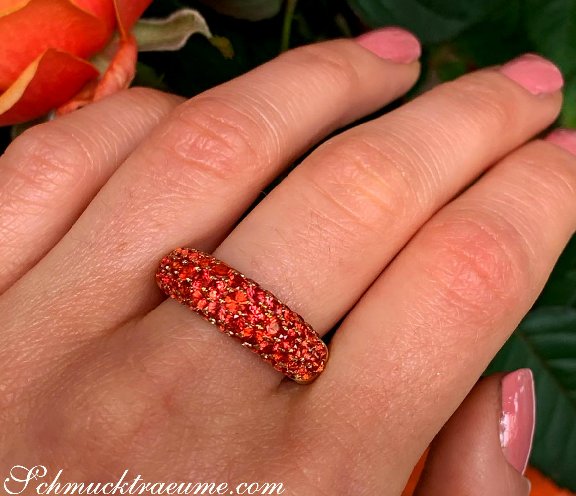 Edler Saphirring mit orangen Steinen auf Gelbgoldfinger