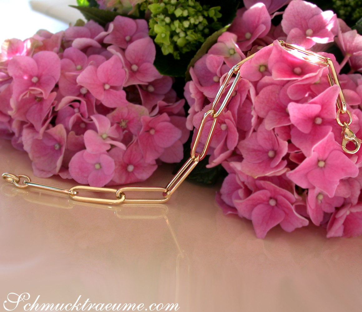 Gold-Paperclip-Armband auf rosa Hortensienblüten, minimalistisch und elegant.