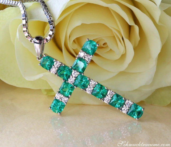 Weißgold Kreuzanhänger mit Smaragden und Brillanten, detailreich, vor Rose. Weißgold Kreuzanhänger mit Smaragden und Brillanten, detailreich, vor Rose.