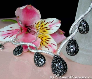 Flora und Luxus: Schmuck mit schwarzen Diamanten und Brillanten auf Blume abgebildet