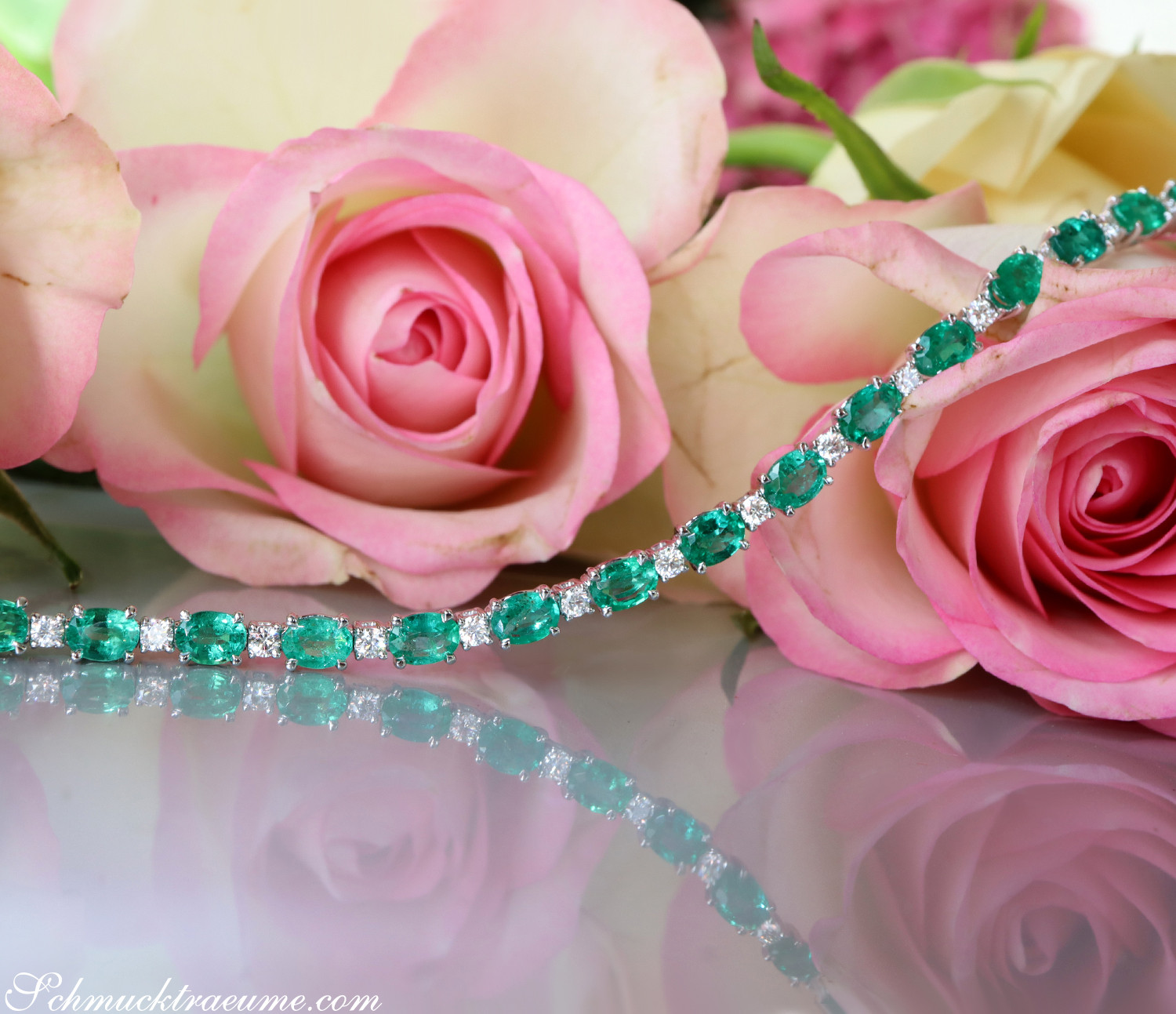 Detailansicht von Smaragd-Armband mit Brillanten auf Rosenblüten