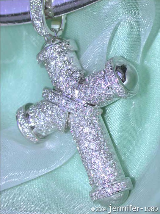 Diamant-Kreuzanhänger in Weißgold 750 auf grünem Stoff, detailreich.