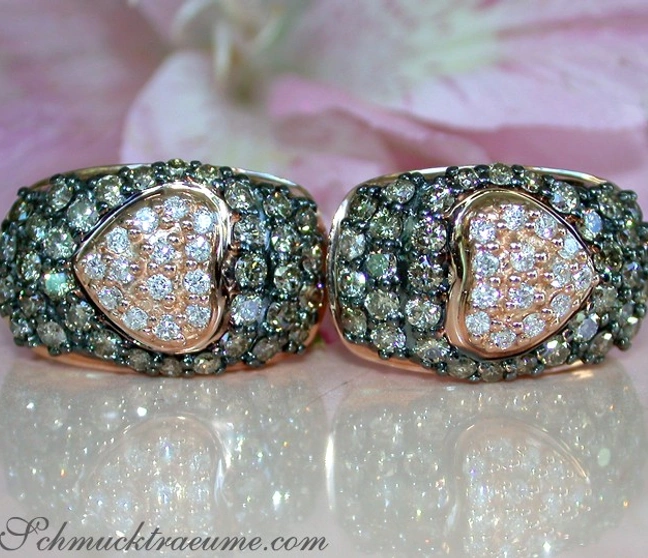 Goldene Herzohrringe mit braunen und weißen Diamanten auf roségoldener Basis. Goldene Herzohrringe mit braunen und weißen Diamanten auf roségoldener Basis.