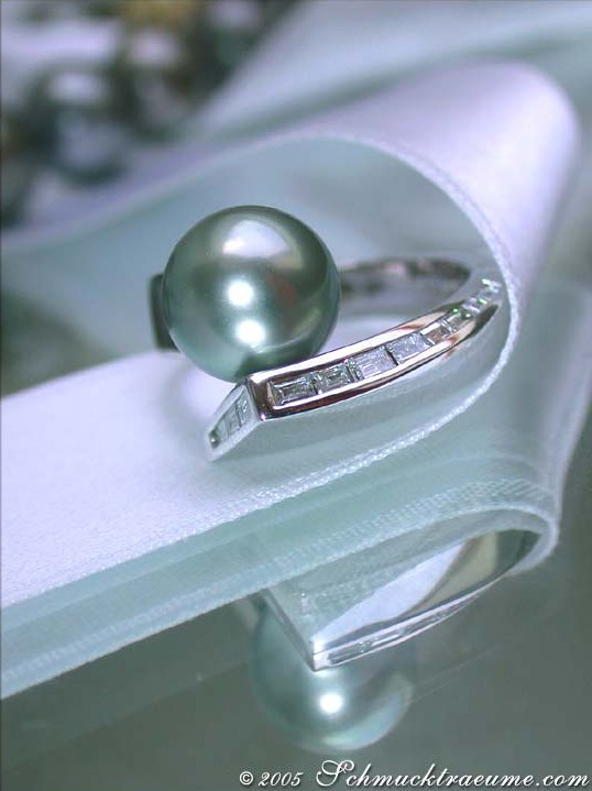 Silberner Ring mit Tahitiperle und Diamanten, Detailaufnahme auf silberner Stoffrolle