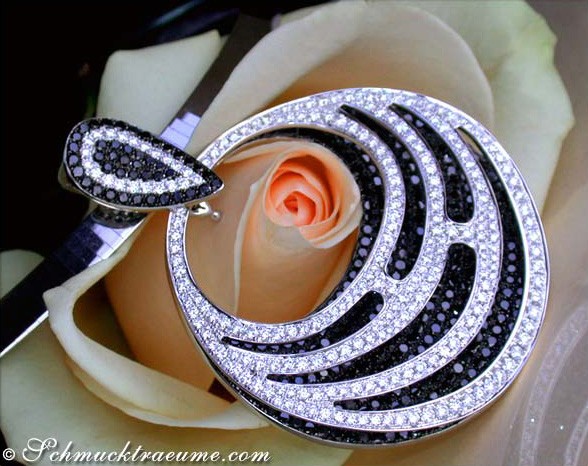 Schwarz-weißer Diamant-Anhänger mit Wellenform, detailreich, auf Rosenblüte liegend.