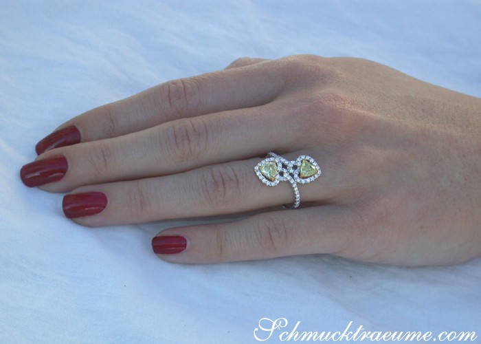 Femininer Herzring mit gelben Diamanten und Brillanten, Detailaufnahme auf Hand mit roten Nägeln.