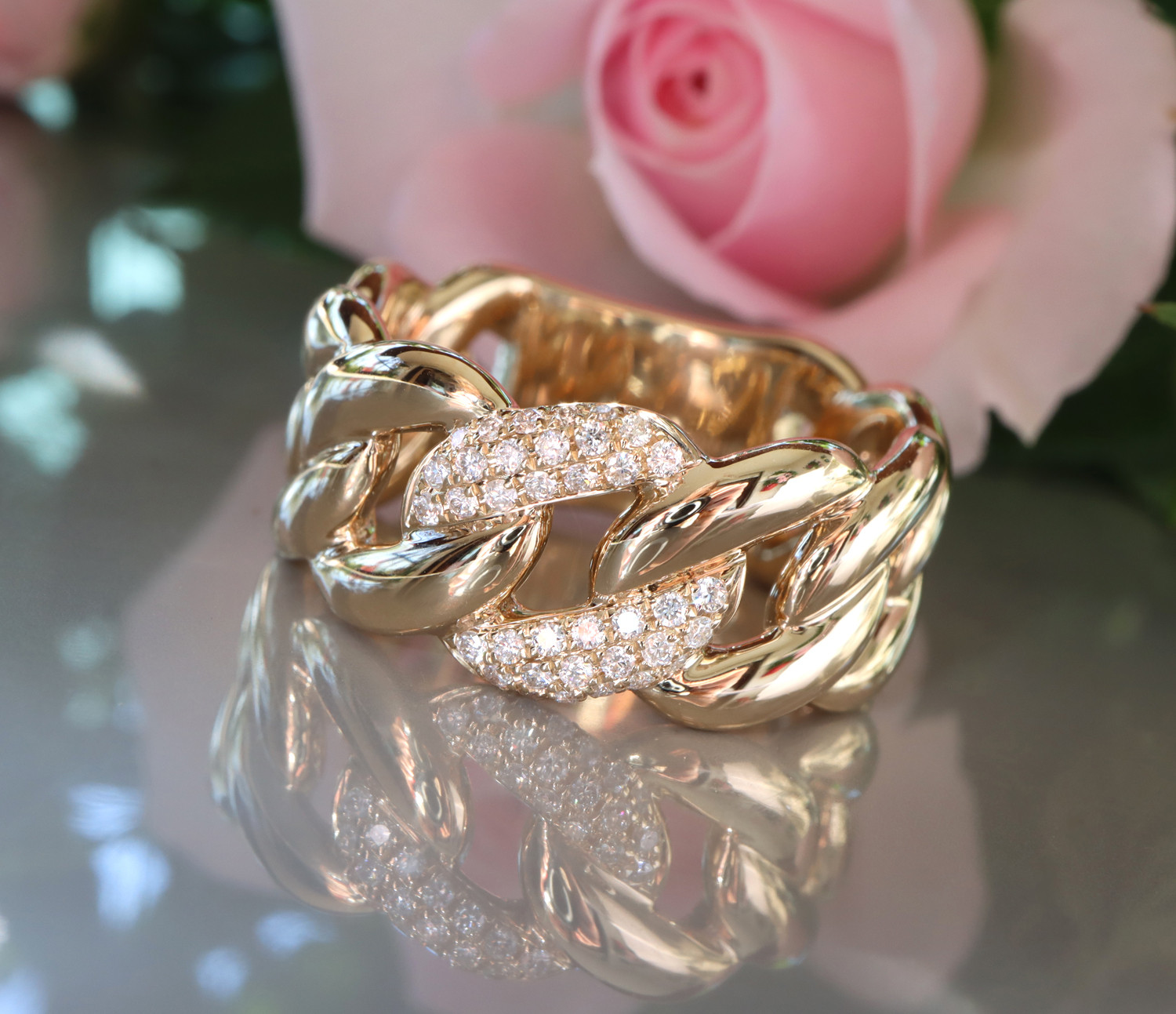 Gelbgold-Ring mit Diamanten, Detailaufnahme, Rosen im Hintergrund