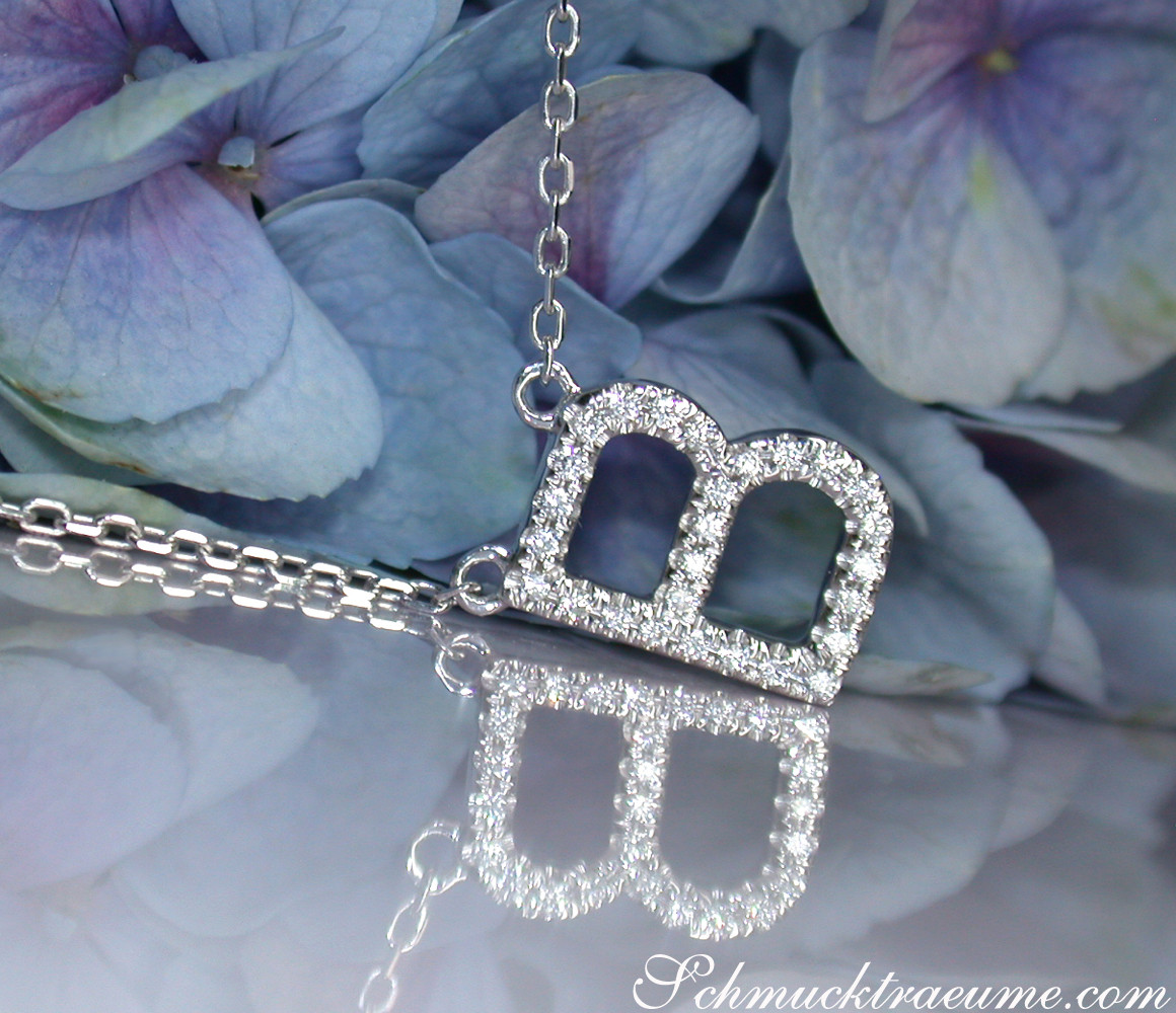 Blütenhintergrund mit zarter Halskette mit Brillanten-Initiale, detailreich, elegant.