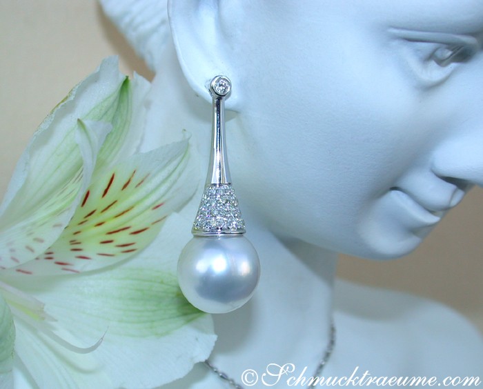 Südseeperlen-Ohrstecker mit Brillanten, detailreich verarbeitet, elegant auf weißem Mannequin mit Blume.