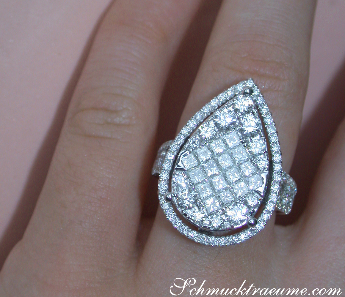 Klassischer Diamant-Tropfen-Ring mit Princess- und Brillantschliff, Detailaufnahme auf Hand