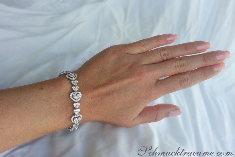Diamant Herz-Armband mit 8.95 ct., Weißgold 750, detailreiches Herz-Design auf Hand, weißer Hintergrund.