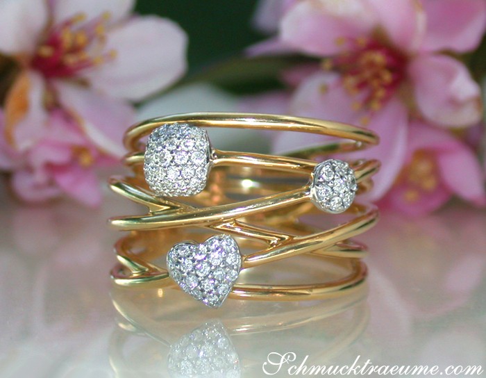Gelbgold-Ring mit Diamantkugeln und Herzform, floraler Hintergrund
