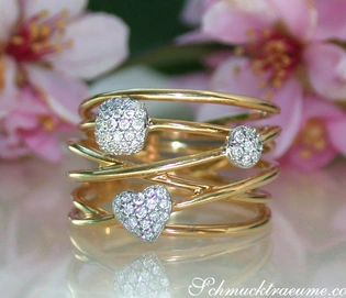 Gelbgold-Ring mit Diamantkugeln und Herzform, floraler Hintergrund