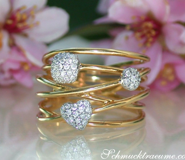 Gelbgold-Ring mit Diamantkugeln und Herzform, floraler Hintergrund Gelbgold-Ring mit Diamantkugeln und Herzform, floraler Hintergrund