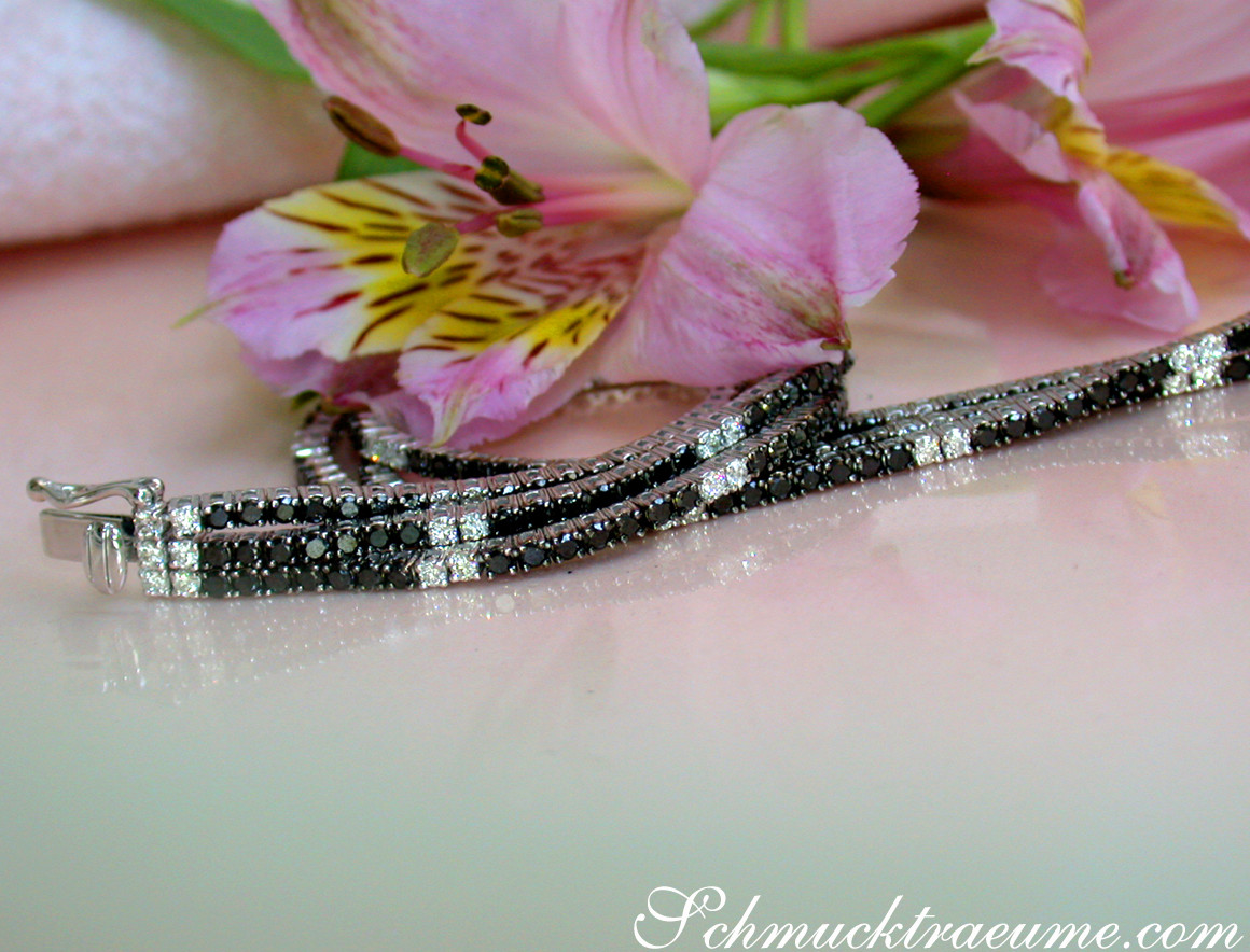 Schwarz-weißes Diamant-Tennisarmband mit Strass, Blumen im Hintergrund.