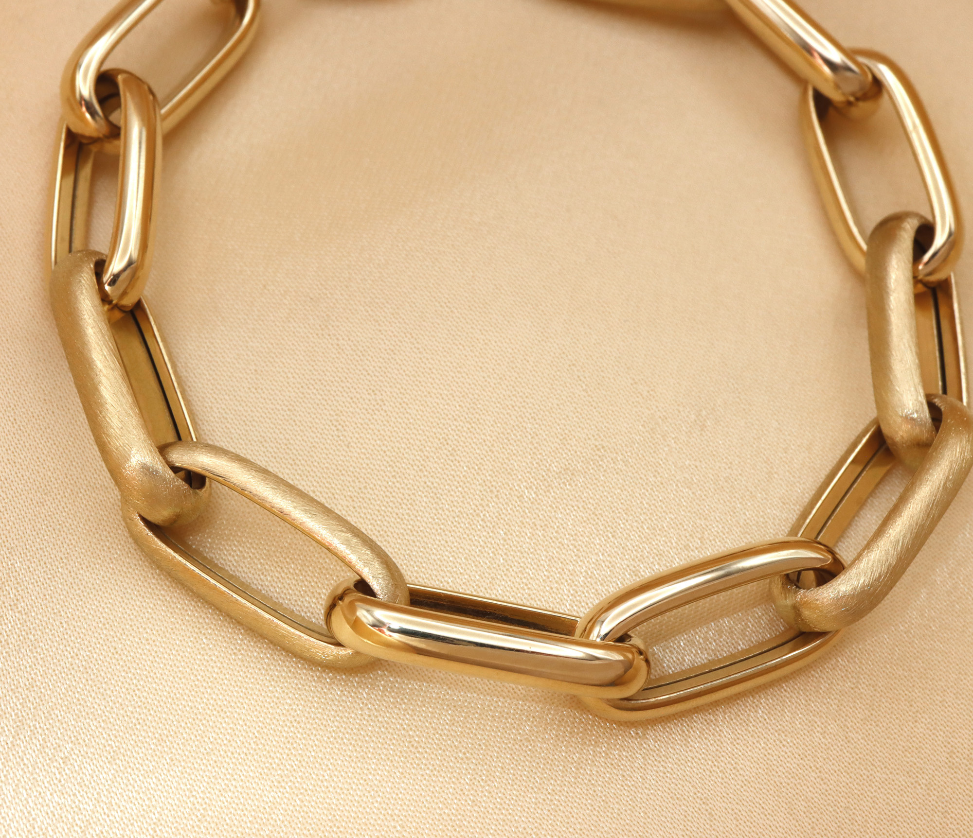 Goldarmband aus 585er Gelbgold mit satinierten und glänzenden Verzierungen, Detailaufnahme.