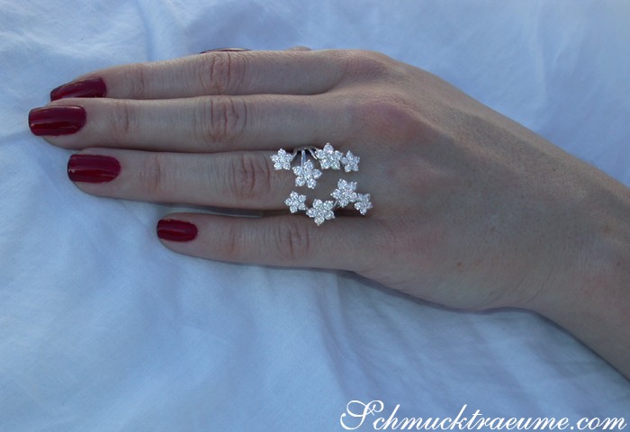 Weißgold-Blütenring mit Brillanten, Hand mit rotem Nagellack, Detailaufnahme