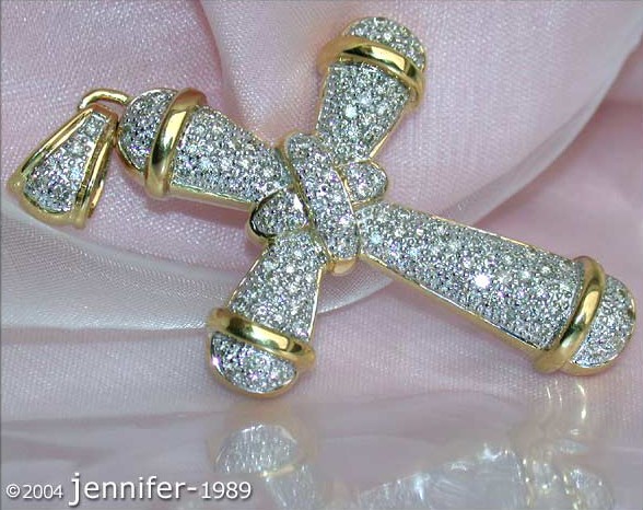 Goldener Kreuzanhänger mit Diamanten besetzt, Detailaufnahme auf Silberunterlage