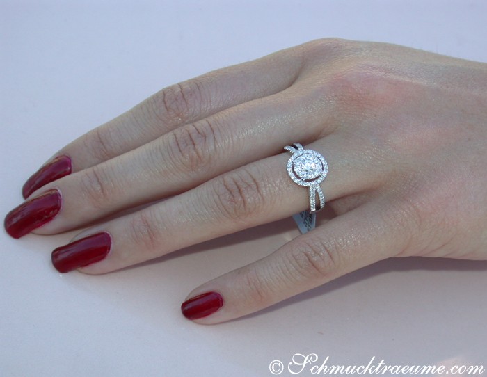 Sehr eleganter Brillantenring in Weißgold, 0.690 Karat, getragen auf der Hand mit roten Nagellack.