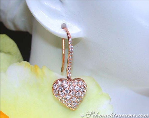 Goldener Herzohrring mit Diamanten, detailreiches Design, elegant auf Blume präsentiert