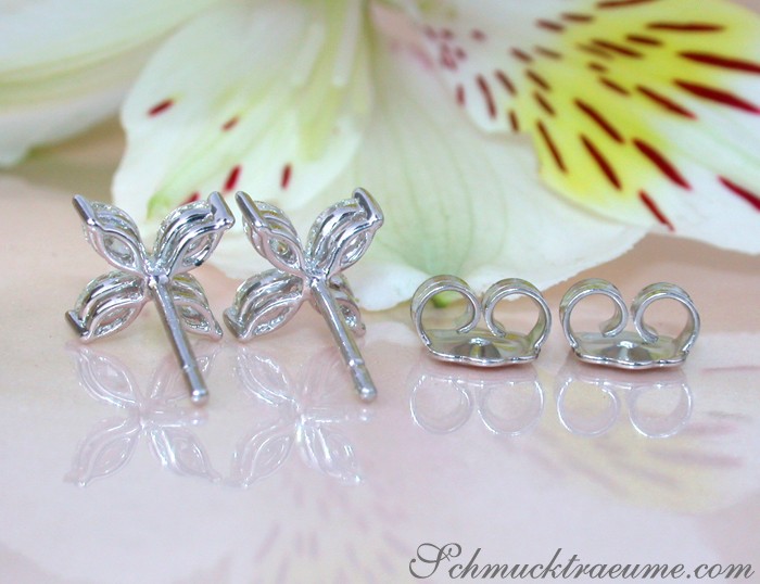 Silberne Ohrstecker mit Blütenmotiv auf glänzender Unterlage