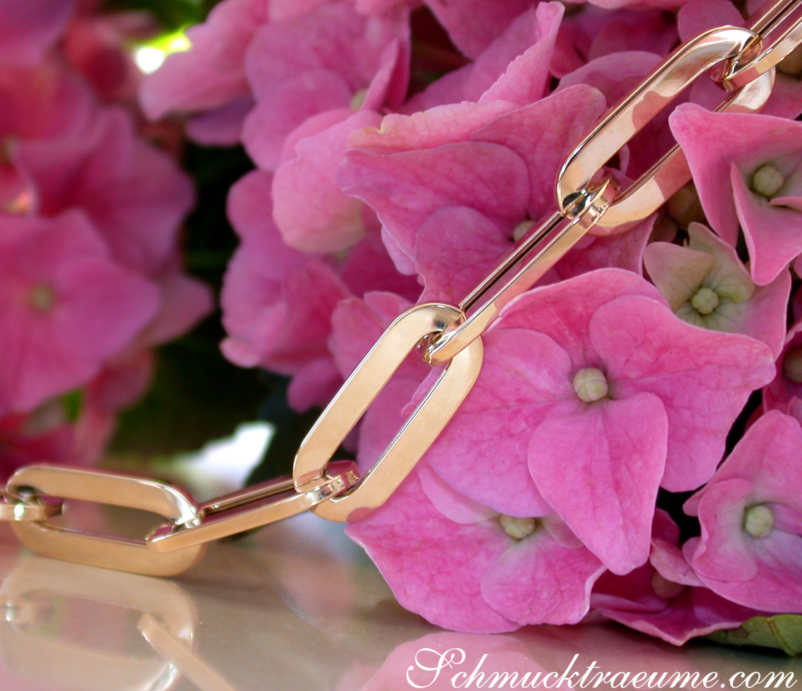 Gold-Paperclip-Halskette aus Gelbgold 585, detailreich gearbeitet, vor rosa Hortensienblüten.