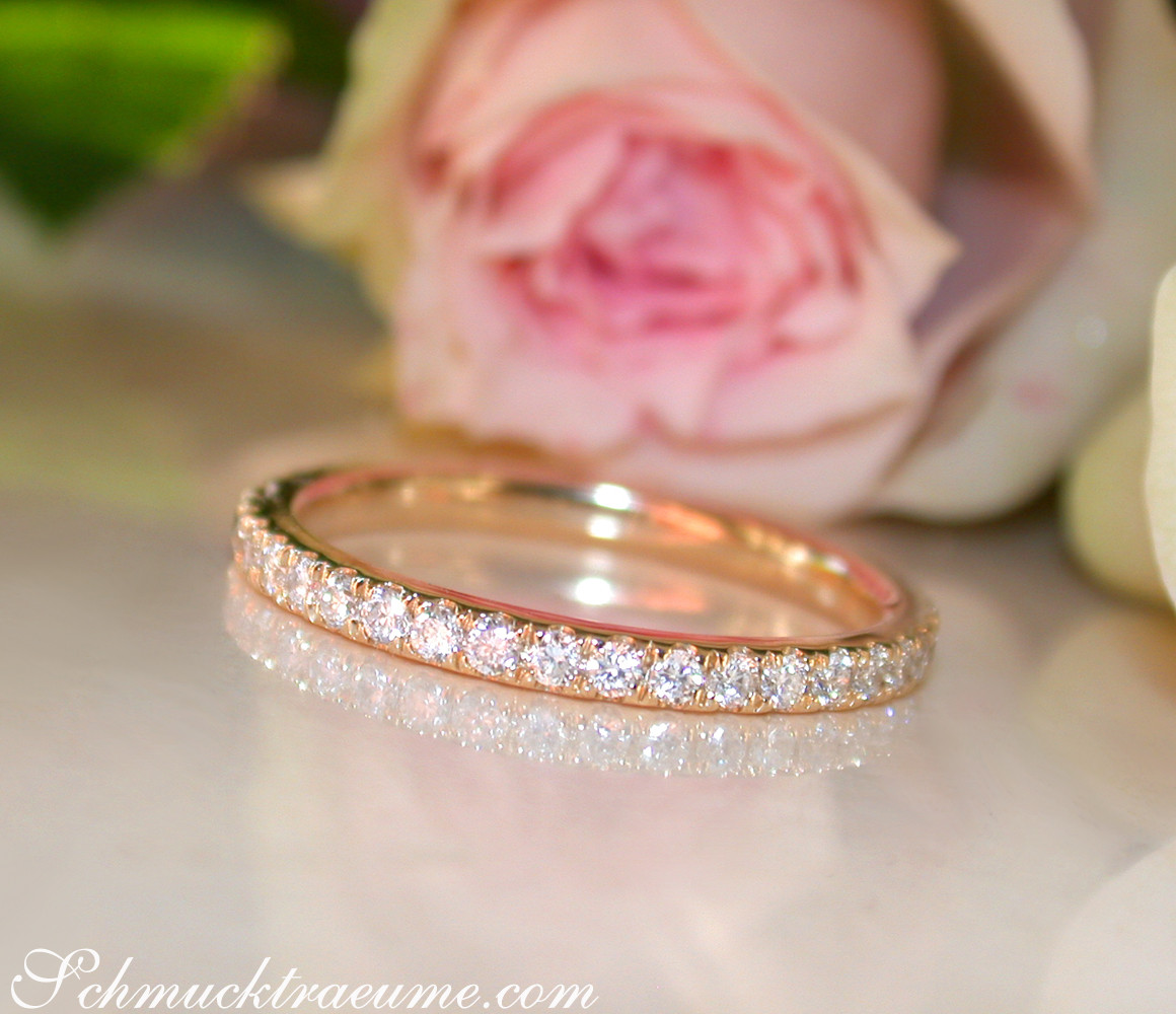 Rosenblüte und Goldring mit Brillanten vor weißem Hintergrund