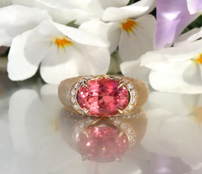 Rosa Turmalin Brillanten-Ring auf weißem Hintergrund mit Blüten Rosa Turmalin Brillanten-Ring auf weißem Hintergrund mit Blüten