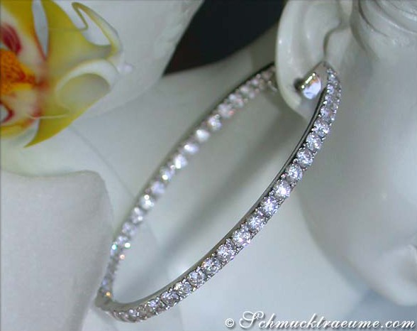 Weißgold-Brillanten-Creolen mit 8,77 ct. auf weißem Porzellan mit Orchidee