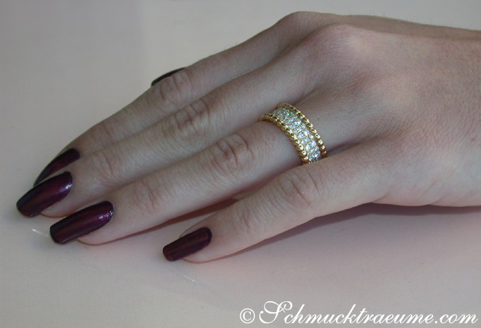 Goldener Brillanten-Memory-Ring auf Hand mit dunklen Nagellackfarben