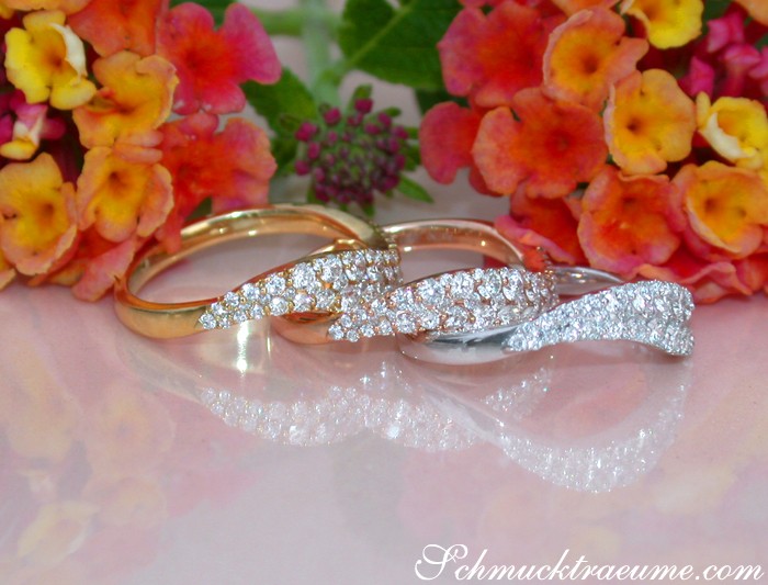 Blumige Blütenhintergrund mit drei geschwungenen Brillanten-Ringen aus Gelb-, Rosé- & Weißgold 750