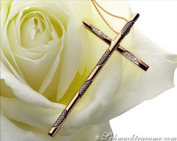 Weißer Rosenblütenhintergrund mit roségoldener Kreuzanhänger mit Brillanten und schwarzen Diamanten.