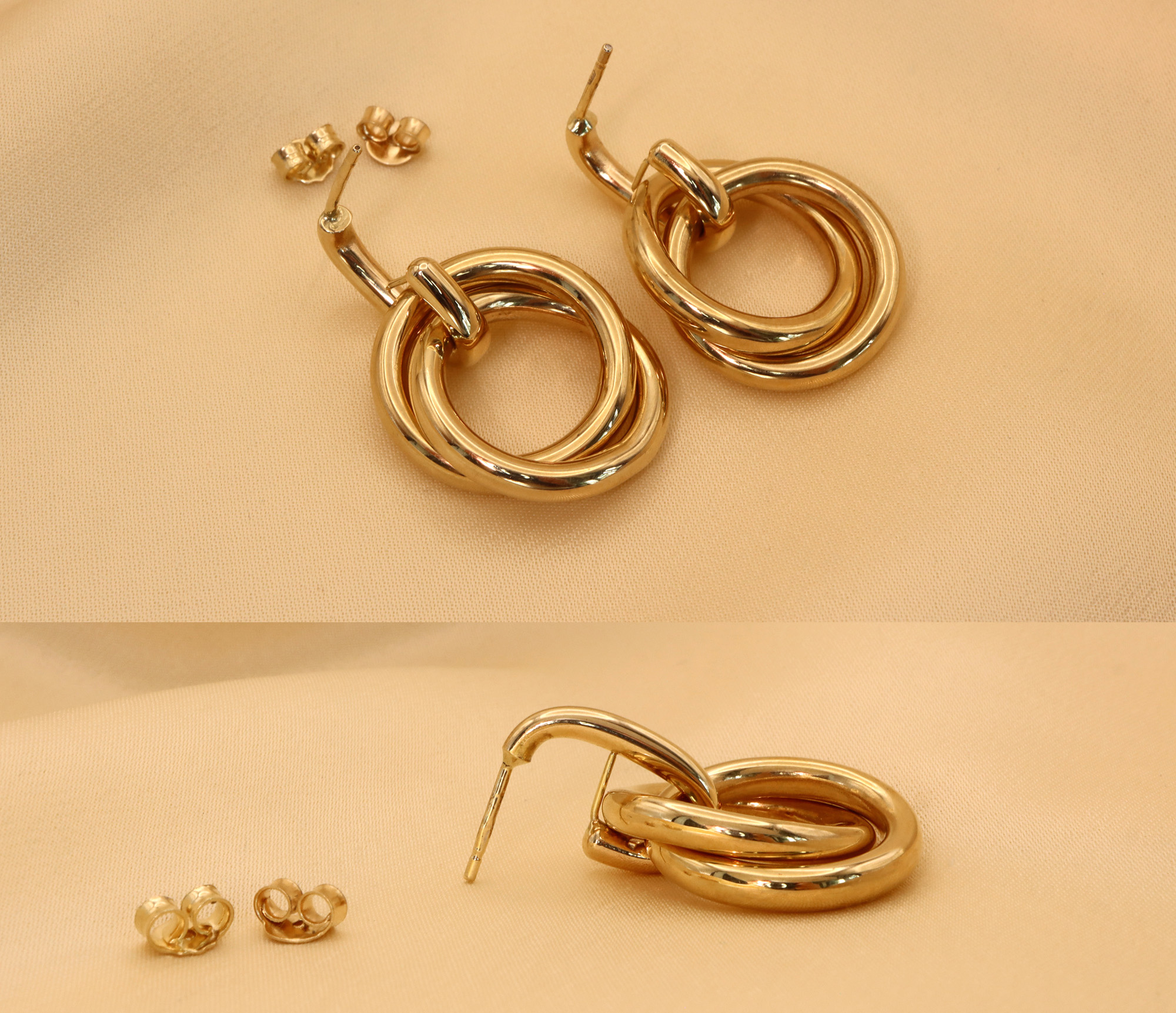 Goldene Ohrringe mit verschränkten Ringen auf beige Hintergrund