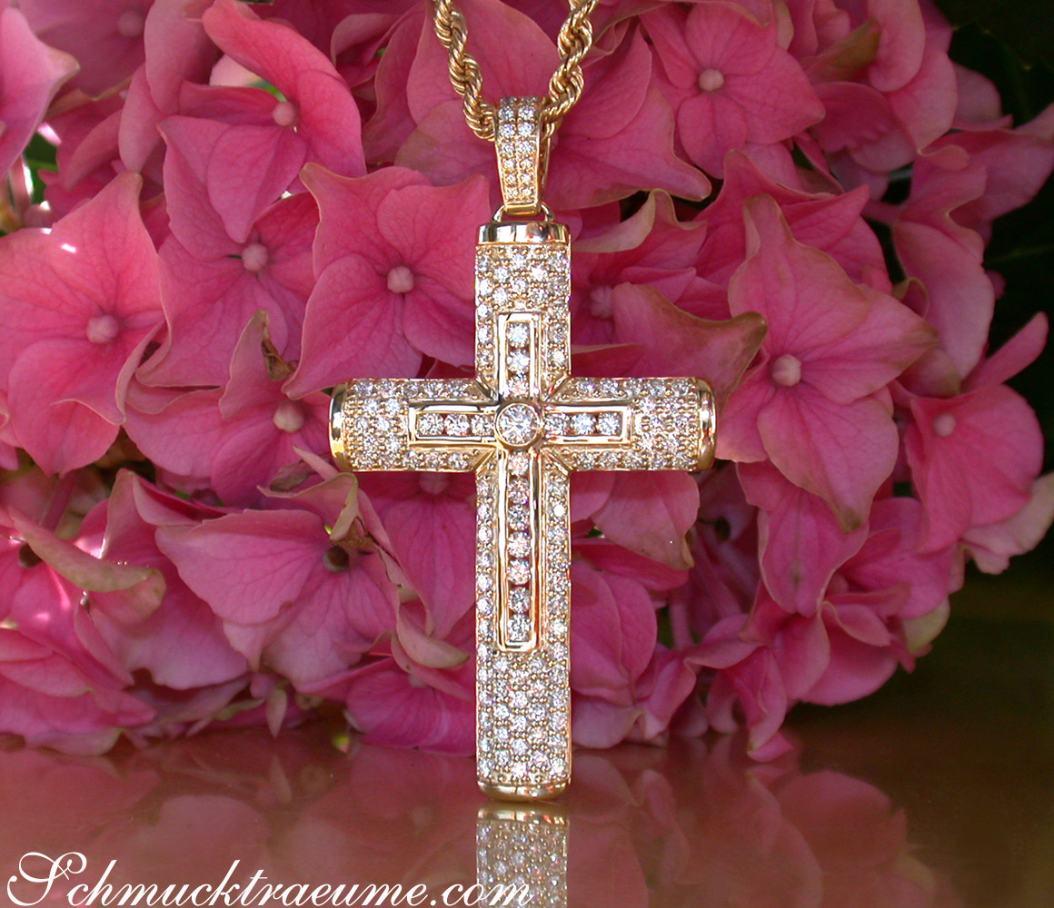 Goldener Kreuzanhänger mit Diamanten auf Rosenhintergrund