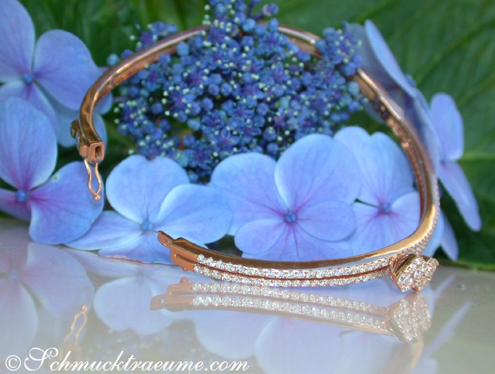 Blauer Hortensienblütenhintergrund mit sanft geschwungenem Diamant-Armreif in Roségold