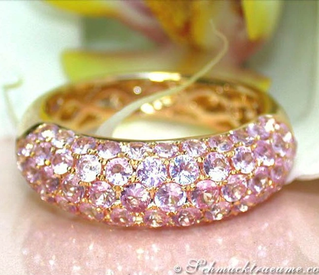 Rosenfarbener Saphir-Pavéring aus Gelbgold 585, Detailaufnahme mit glänzenden Steinen. Rosenfarbener Saphir-Pavéring aus Gelbgold 585, Detailaufnahme mit glänzenden Steinen.