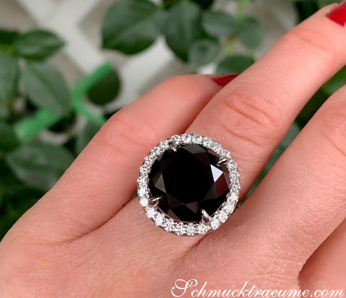 Schwarzer Diamant Solitär-Ring mit Brillanten, Detailaufnahme, Handgetragen, grüner Hintergrund