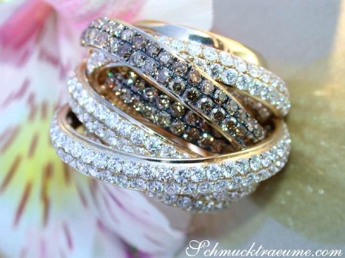 Verziertes Goldringset mit Diamanten und naturbraunen Steinen auf Blume