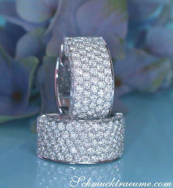 Detailansicht von Brillantenohrringen in Weißgold 750, glänzende Brillanten, blauer Hintergrund.