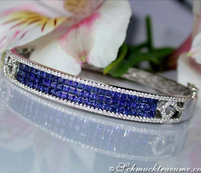 Luxusarmreif aus Weißgold mit Saphiren und Brillanten, Blüten im Hintergrund Luxusarmreif aus Weißgold mit Saphiren und Brillanten, Blüten im Hintergrund