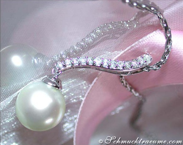 Weißgold-Anhänger mit Südseeperle und Brillanten, Detailaufnahme auf rosa Satin.