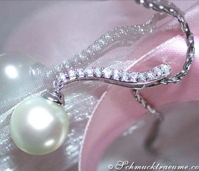 Weißgold-Anhänger mit Südseeperle und Brillanten, Detailaufnahme auf rosa Satin. Weißgold-Anhänger mit Südseeperle und Brillanten, Detailaufnahme auf rosa Satin.