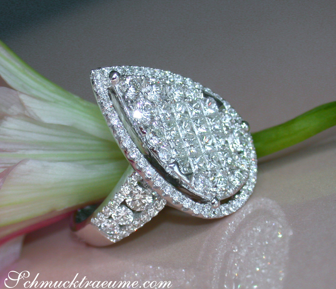Diamant-Tropfen-Ring mit Princess- & Brillantschliff, detailreich, auf Blüte präsentiert